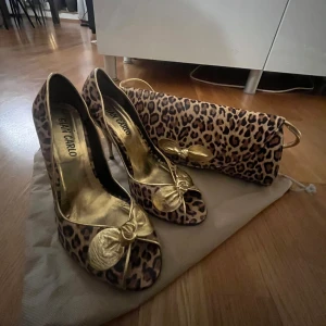 Leopard väska och matchande klackskor - Både är använda endast 1-2 gånger. Klackskorna är i 39 men hade även passat 38. De är gjorde i libanon. Väskan 200kr och Klackskorna 200kr var för sig men 300kr tillsammans. Säljer eftersom de ej passar och inte kommer till användning.