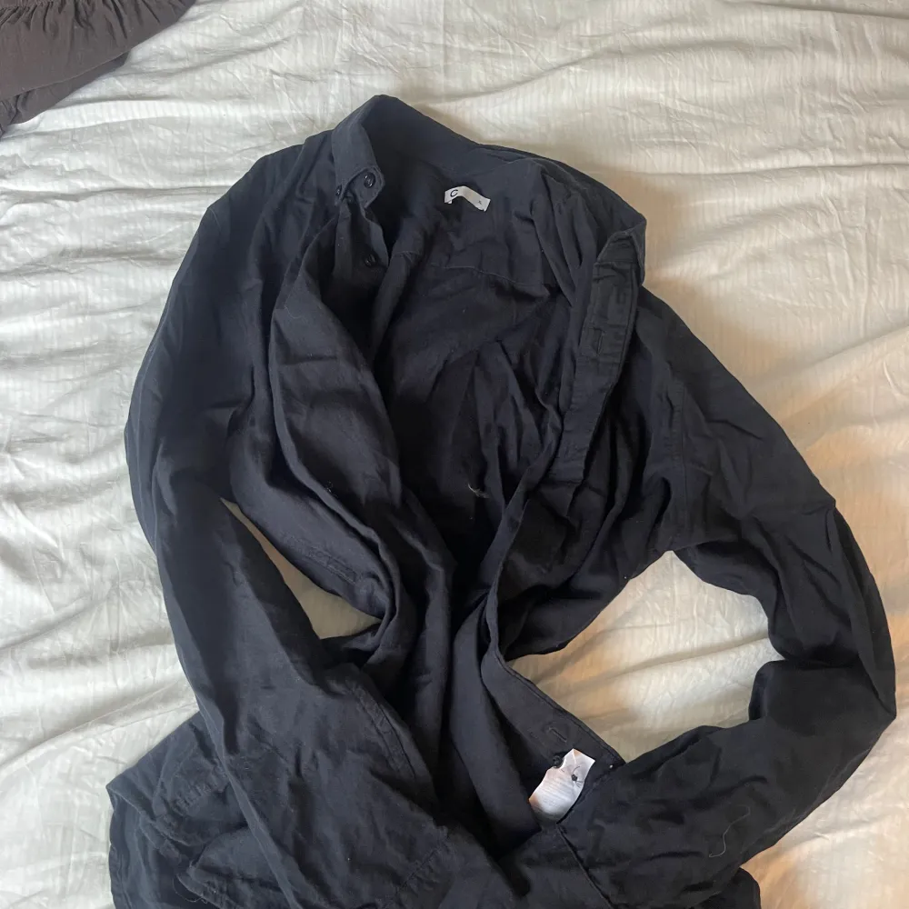 Säljer en stilren svart skjorta från märket C i storlek XL. Skjortan har långa ärmar och är perfekt för en avslappnad look. Den är tillverkad i ett mjukt material som ger en bekväm passform.. Paidat.