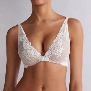 Vit spets-bh - Elegant vit spets-bh med v-ringad design och fina spetsdetaljer. Perfekt för en romantisk look. Axelbanden är justerbara för bästa passform. Från intimissimi💞