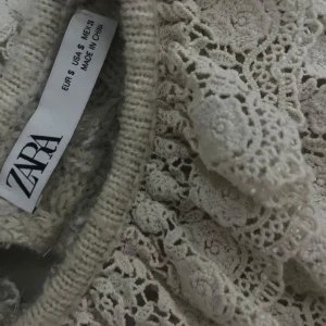 Beige spetsdetaljerad tröja från Zara - Säljer en beige tröja från Zara med vackra spetsdetaljer och stickat mönster. Den har en elegant design med fina detaljer som ger en unik look. Det står storlek s men skulle säga att den passar både xs och s💗