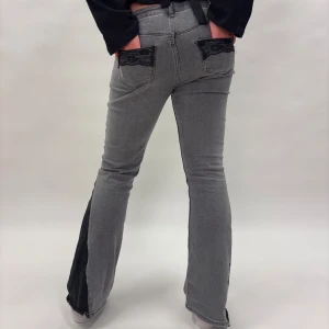 Gråa bootucut jeans med spetsdetaljer - Gråa skinnyjeans som är omsydda till bootcut, med en svart detalj vid bensluten och spets på fickan😁Modellen är 167 lång och byxorna är lite korta för henne!
