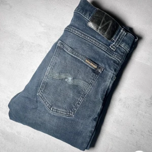 Mörkblå jeans från Nudie Jeans - Snygga mörkblå jeans från Nudie Jeans med klassisk femficksdesign och subtila sömdetaljer på bakfickorna. Perfekt för en stilren look. Pris kan diskuteras vid snabb affär 