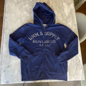 Blå Ralph Lauren zip hoodie  - Skick: 8/10. Tröjan är i bra skick och har inga defekter. Från märket Ralph Lauren i storleken M. Om du är osäker om den kommer att passa kan du alltid fråga om måtten!