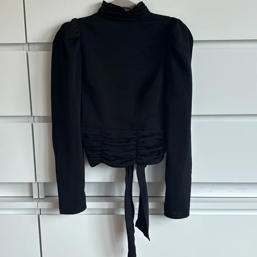 Säljer min älskade svarta blus med öppen rygg och knytning där bak från Gina Tricot🩷har använts väldigt varsamt  och är därför fortfarande i otroligt bra skick🫶🏻perfekt till en mer festlig kväll!. Puserot.