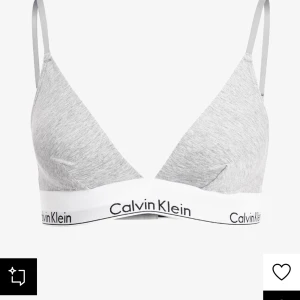 Grå triangel-bh från Calvin Klein - Säljer en stilren grå triangel-bh från Calvin Klein med justerbara axelband och elastiskt band med logotyp. Perfekt för en bekväm och avslappnad stil.