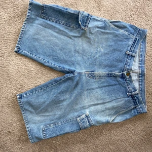 Oversized jorts - Ett par oversized jeansshorts perfekt för sommaren! Fickor finns fram, på sidan och bak. Fint skick :) Liten reva på väster bakficka som enkelt går att fixa. Storlek står inte på byxorna men jag är en 36 i höfterna och utan bälte sitter byxorna lite hängiga. 