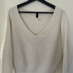 Vit stickad tröja med v-ringning - Säljer en stilren vit stickad tröja med v-ringning. Tröjan har långa ärmar och en ribbad kant vid ärmslut och nederkant. Storlek Xs men sitter väldigt bra på en med S också! Använd någon enstaka gång 