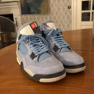  Nike Air Jordan 4  i ljusblå mocka - Snygga Nike air jordans 4 i ljusblå mocka med svarta och vita detaljer. Nästan aldrig använda!!