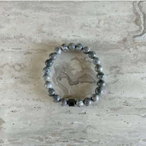 Grått armband med stenar - Snyggt armband med gråa stenar som ger en stilren look. Perfekt accessoar för att komplettera din outfit. Elastiskt band för enkel passform.