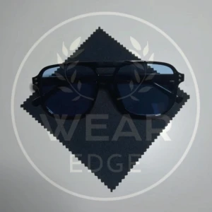 Svarta solglasögon från Wear Edge - Snygga svarta och blåa solglasögon med en modern design från Wear Edge. De har en kantig form och mörka linser som ger ett stilrent intryck. Perfekta för att skydda ögonen mot solen samtidigt som de ger en cool look.