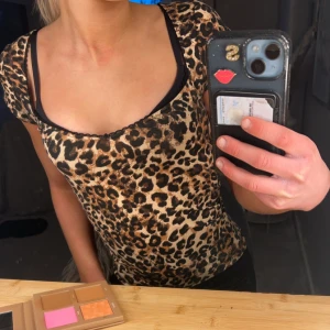 Leopardmönstrad topp från Nelly - Säljer en snygg leopardmönstrad topp från Nelly i storlek XXS. Toppen har en v-ringad design med svarta spetsdetaljer längs kanten. Nästan nytt skick jätte fin och använd väldigt få gånger!✨🐆