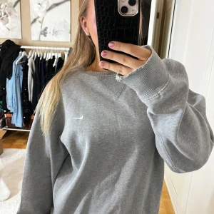 Grå sweatshirt från Nike - Säljer en grå sweatshirt från Nike i bra skick, men med en liten reva vid ärmslutet. Den är superbekväm och har en normal passform. 