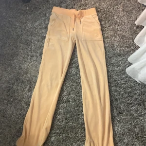 Ljus orange mjukisbyxor från Juicy Couture - Säljer ett par superbekväma ljus orange mjukisbyxor från Juicy Couture i storlek XXS.