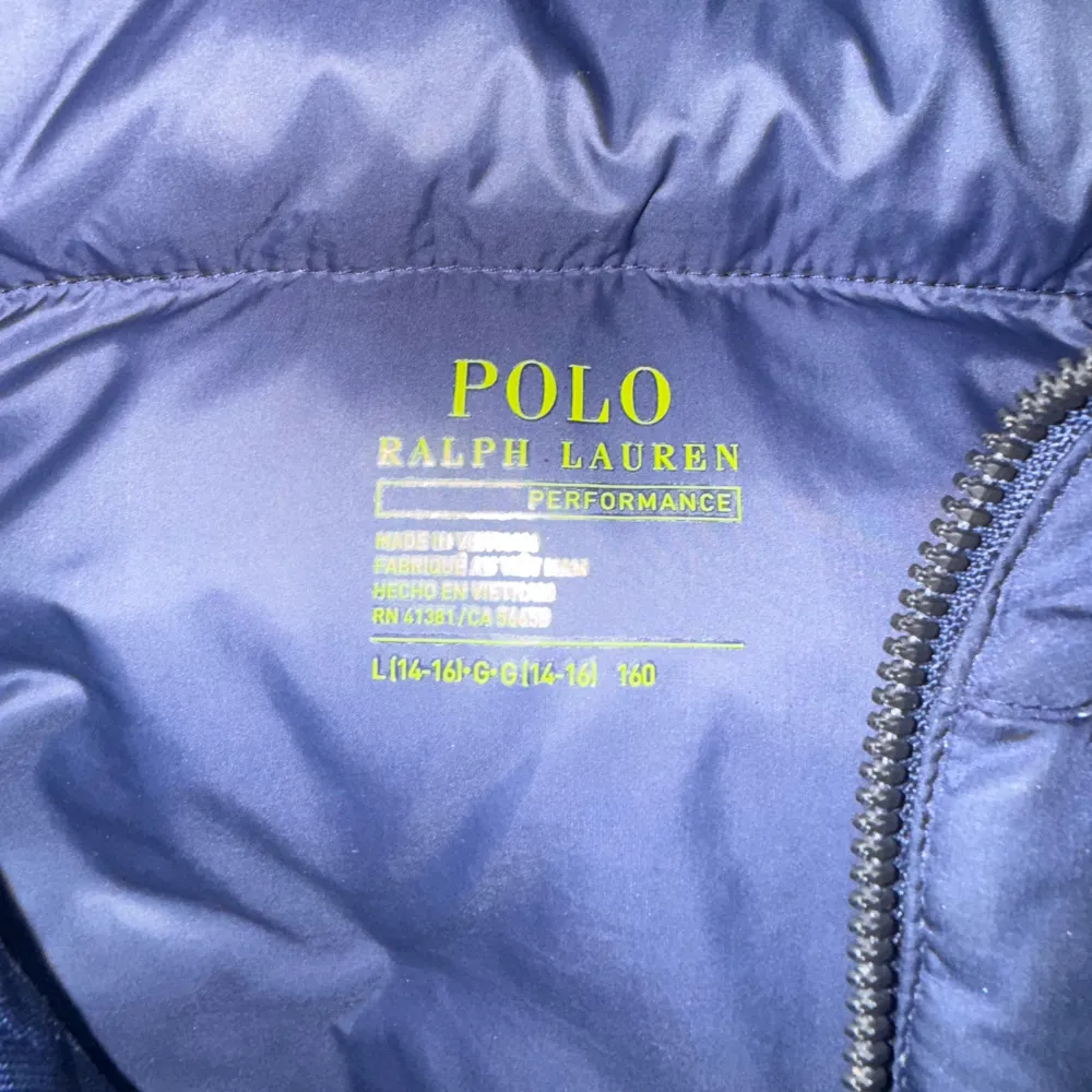 Säljer en snygg blå dunjacka från Polo Ralph Lauren. Jackan har en praktisk huva och dragkedja framtill. Perfekt för kalla dagar med sin varma och puffiga design. Passar både till vardags och lite finare tillfällen. 🧥💙. Jackor.