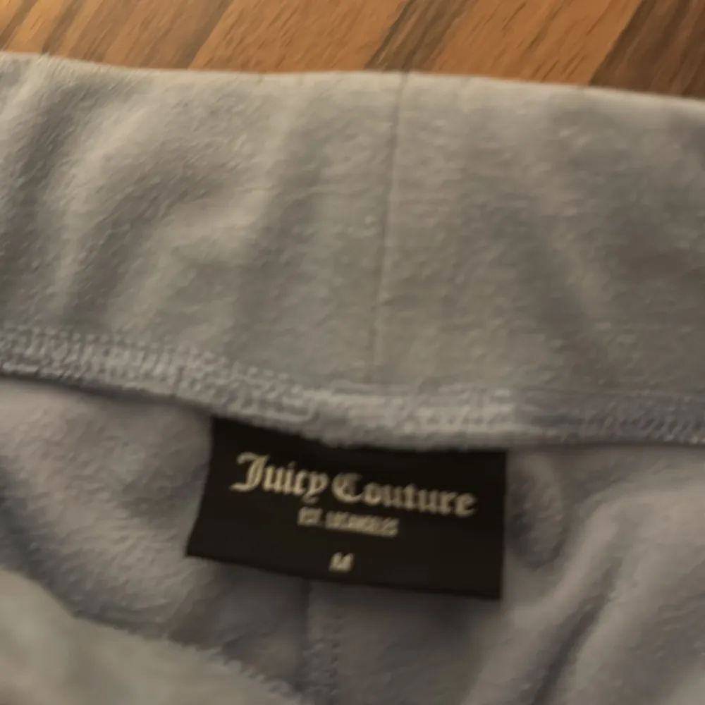 Säljer ett par superbekväma ljusblå mjukisbyxor från Juicy Couture i storlek M. Byxorna har en loose passform och är gjorda i mjuk velour, perfekt för mysiga dagar hemma. De har en elastisk midja och praktiska fickor fram. Perfekta för både chill och stil! 💙. Jeans & Byxor.