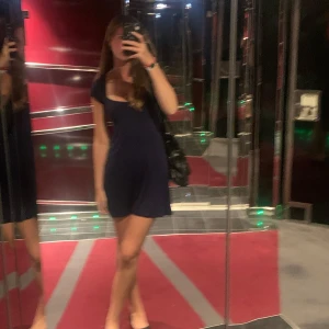 Mörkblå klänning med korta ärmar - Säljer en stilren mörkblå klänning med korta ärmar och en v-ringad hals. Perfekt för både vardag och festliga tillfällen. Klänningen har en smickrande passform och är superbekväm att bära. Passar perfekt till sommaren eller våren!  Har använt en enstaka gång så den är i bra skick, skriv för mer bilder💞