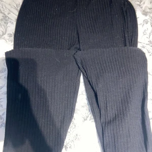 Svarta ribbade byxor från Gina Tricot - Säljer ett par svarta ribbade byxor från Gina Tricot i storlek S. Byxorna har en bekväm passform och är perfekta för både vardag och mysiga hemmakvällar. De är i helt okej skick men har lite knottror där av priset. 