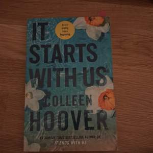 Säljer boken 'It Starts With Us' av Colleen Hoover. Omslaget är blått med vita och orange blommor. Perfekt för dig som älskar romantiska berättelser och vill veta vad som händer efter 'It Ends With Us'.