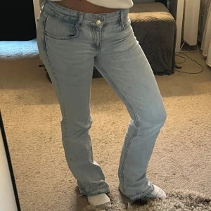 Ljusblå bootcut jeans - Säljer ett par ljusblå bootcut jeans i bra skick. De har en snygg slitsdetalj vid fållen och är lågmidjade för en avslappnad look. Perfekta för vår och sommar! Passar till både vardag och fest. TVÄTTAR självklart dom innan jag postar💕Midje mått- 34cm, innerbens- 80cm💕