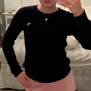 Mörkblå tröja från Abercrombie & Fitch - Säljer en stilren märkblå tröja från Abercrombie & Fitch. Den har en liten vit logga på bröstet och är perfekt för både vardag och fest. Tröjan är långärmad och har en normal passform. Supermjuk och bekväm!