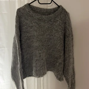 Stickad tröja  - Mysig och fluffig grå tröja från Dazy i storlek XL men den är väldigt liten i storlek så passar mindre. Perfekt för kyliga dagar med sin mjuka och varma känsla. Tröjan har en enkel design med långa ärmar och rund halsringning.🥰Aldrig använd