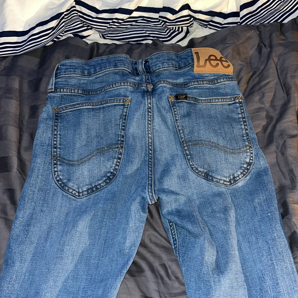 Säljer ett par klassiska blå jeans från Lee i modellen Luke. De har en straight passform och är i bra skick. Perfekta för vardagsbruk med en snygg tvätt och bekväm känsla. Passar både till avslappnade och mer uppklädda tillfällen.. Jeans & Byxor.