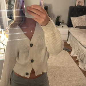 Vit stickad kofta med knappar - Säljer en superfin vit stickad kofta med stora knappar framtill. Den är perfekt för både höst och vår. Koftan är i mycket bra skick. 