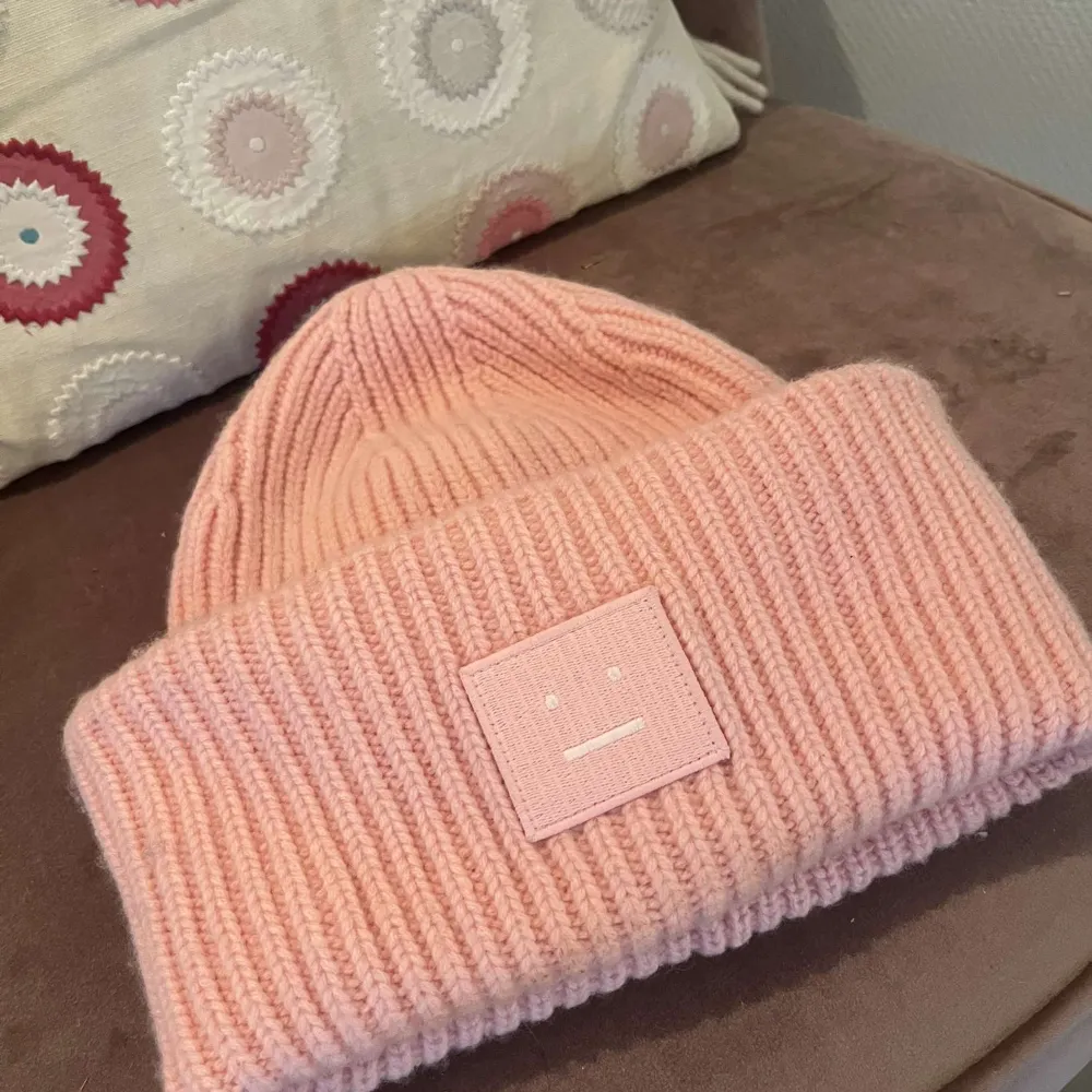 Superfin rosa stickad mössa från Acne Studios. Knappt använd, utan några defekter. Perfekt för att hålla sig varm och snygg under kyliga dagar. Den ribbade designen ger en skön passform och den mjuka färgen är lätt att matcha med olika outfits. Vid fler fråger är det bara att skriva till mig!🌸. Accessoarer.