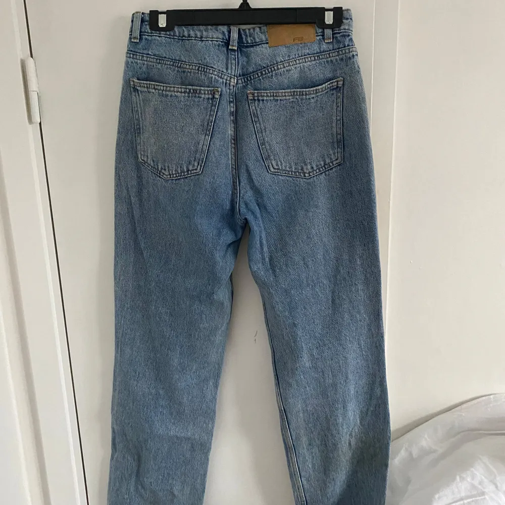 Säljer ett par klassiska blå jeansbyxor i bra skick. De är högmidjade med en straight passform, perfekt för både vardag och fest. Jeansen har en snygg vintage-look. Passar perfekt till en t-shirt eller en snygg blus!. Jeans & Byxor.