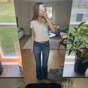 Beige kortärmad topp med knappar - Säljer en söt beige kortärmad topp med knappar framtill. Toppen har en enkel men stilren design, perfekt för både vardag och fest. Den är i bra skick och passar till det mesta i garderoben. Perfekt för vår och sommar!🤍