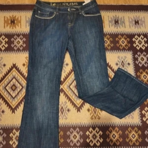 Blå jeansbyxor - Säljer ett par klassiska blå jeansbyxor i bra skick. De har en normal passform och är perfekta för vardagsbruk. Byxorna har en knapp och dragkedja framtill samt fickor både fram och bak. Perfekta för höst och vår!