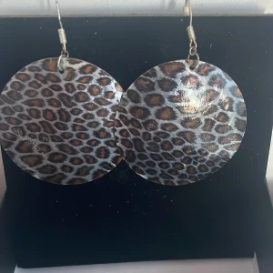 Leopardmönstrade örhängen - Snygga och trendiga örhängen med leopardmönster. De är stora och runda, perfekta för att ge en djärv touch till din outfit. Passar både till vardags och fest. 🐆✨