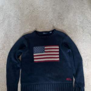 Säljer en snygg mörkblå tröja från Polo Ralph Lauren i storlek xl barn men passar också XS . Den är gjord av 100% bomull och har en cool amerikansk flagga broderad på framsidan. Perfekt för höst och vinter, och den är i mycket bra skick. Passar både till vardags och festliga tillfällen! Nypris ca 6000 mitt pris: 1800 kom privat för mer minsta möjliga fråga, vid snabbaffär kan jag sänka priset lite!🤝