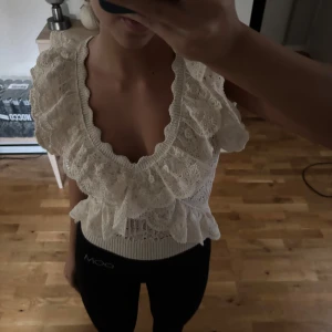 Spetsblus med volanger - Säljer en superfin spetsblus med volanger. Den har en djup v-ringning.