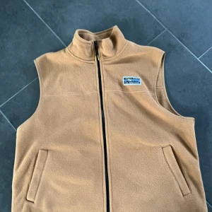  fleeceväst  - Säljer en snygg beige fleeceväst från Junkyard i storlek S. Västen har en dragkedja framtill och två praktiska fickor. Perfekt för höst och vår när du vill hålla dig varm men ändå se stilren ut. Passar både till vardags och lite mer avslappnade tillfällen.