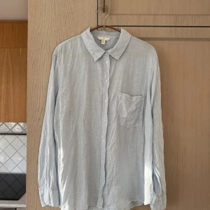 Ljusblå linneskjorta från H&M - Storlek L - Fräsch ljusblå linneskjorta från H&M i storlek L. Perfekt för varmare dagar och ger en avslappnad men stilren look!