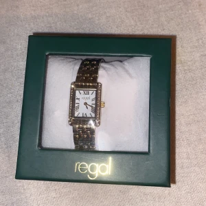 Guld klocka med glitter  - Jag säljer denna guld klocka med glitter på då jag är en silver tjej och den gick inte att lämna tillbaka! Med det sagt så är klockan aldrig använd och prislapp samt skydds plast sitter kvar! Orginalförpackningen är även kvar! Nypris 400kr