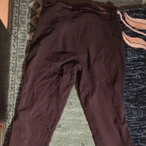 Unika svarta skinn/latexbyxor - Säljer ett par snygga bruna skinnbyxor i bra skick. Ena sidan är skin medan den andra är tyg. Framsidan är med latex liknande material. Perfekta för en cool och edgy look, passar både till vardags och fest. Storleken är inte angiven, men de ser ut att ha en normal passform av M