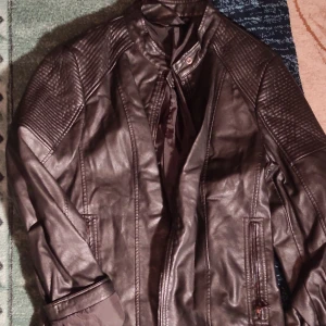 Svart skinnjacka - Säljer en snygg svart skinnjacka i mycket bra skick. Den har coola quiltade detaljer på axlarna och en dragkedja framtill. Perfekt för höst och vår, och funkar lika bra till fest som till vardags. Jackan har en normal passform och långa ärmar.