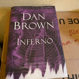 Inferno - Säljer en spännande bok av Dan Brown, 'Inferno'. Den har ett lila omslag med mystiska mönster och är utgiven av Albert Bonniers Förlag. Perfekt för dig som gillar thrillers och mysterier!