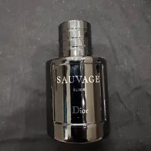 Säljer en flaska Sauvage Elixir från Dior. Flaskan är elegant och mörk med en stilren design. Perfekt för den som vill ha en lyxig och maskulin doft. Passar både till vardags och fest. Flaskan är i gott skick och redo att användas. Perfekt present eller till dig själv! 🌟