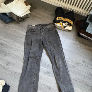 Grå Levis jeans stay loose - Säljer ett par grå Levis jeans i bra skick. De har en klassisk straight passform och är perfekta för både vardag och fest. Jeansen har en snygg tvättad look och är tillverkade i slitstarkt denim. Perfekta för höst och vår!