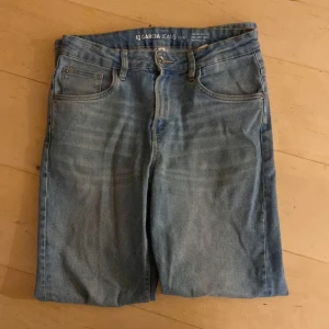 Blå jeansshorts från Garcia Jeans - Säljer ett par snygga blå jeansshorts från Garcia Jeans. De har en klassisk femficksdesign och stängs med dragkedja och knapp. Perfekta för sommardagar eller avslappnade vårutflykter. Storleken är 170, vilket passar bra för tonåringar. Shorts i mycket bra skick!
