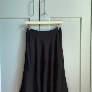 Vintage Silk Bias Skirt - Classic Wardrobe Staple. Vintage Comptoir des Cotonniers in Black Silk Bias Cut skirt. A bias cut is a woven fabric cut on the diagonal in the patternmaking process. Best fits S