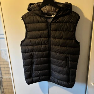 Väst  - Säljer denna as feta väst med luva som är perfekt nu till hösten. Skicket är bra utan defekter. Storleken är XS och sitter bra på mig som är 170cm lång. Priset är inte hugget i sten!
