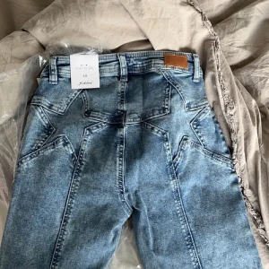 Jeans med stjärnor - Står att det är storlek 40 men skulle säga att de är som storlek 34(xs). Aldrig använda, lapparna är kvar. Köpta för 700kr