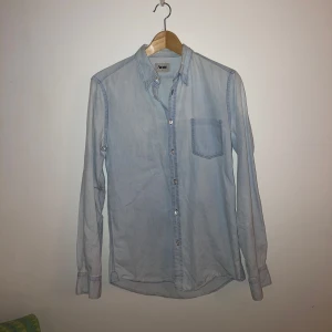 Acne skjorta ifrån A/W-10 - Supersnygg och ovanlig Acne skjorta ifrån höst/vinter kollektionen 2010. Väldigt bra skick. Skjortan har unika detaljer som bl.a. en bröstficka som sitter på insidan av skjortan.  Nuvarande Acne skjortor med samma stuk säljs för 4000kr (se bild 3)