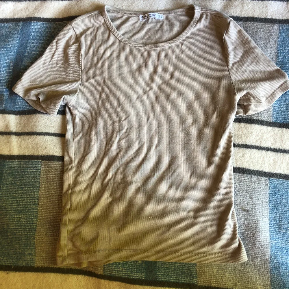 Ribbad beige tshirt, sitter lite tajtare på kroppen 💓 litet hål på framsidan se bild. T-shirts.