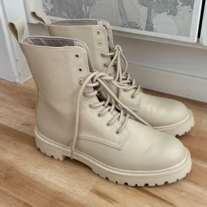 Beiga boots  - Snygga beiga boots/låga stövlar/stövletter med snörning. Endast använda en gång. I storlek 39. I fuskläder som är väldigt enkelt att bara torka av med en fuktig trasa när dom blir smutsiga. Kommer tyvärr inte till användning.