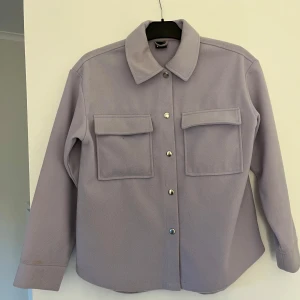 Lila jacka - Lila jacka från Gina Tricot. Har lite defekter i form av missfärgningar vid arm muddarna ( se de sista bildern ), men ändå bra skick.
